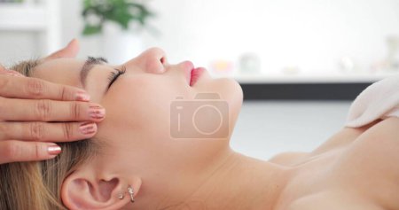 Téléchargez les photos : Gros plan sur le visage de belles femmes asiatiques recevant un traitement de massage facial à la clinique de beauté. Soins de beauté sur le visage. Beauté massage facial, concept de soins de la peau - en image libre de droit