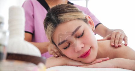 Photo for Close up beautiful Asian woman relaxing and closed eyes lying on massage bed. Relaxing receiving back massage lying closing eyes at romantic luxury spa. Body care concept - Royalty Free Image