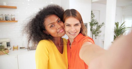 Photo for Young lesbian lgbt couple enjoy taking selfie by smartphone. Two beautiful women lesbian couple live streaming together smiling to camera. Close up portrait, Lesbian lgbt couple - Royalty Free Image