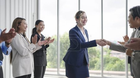 Photo for Group of business people applauding to caucasian woman leader congratulation business achievement. Diverse employees clapping and shaking hands welcoming new manager. Applauding and cheering - Royalty Free Image