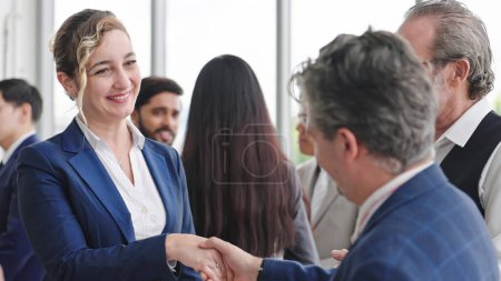 Photo for Caucasian man leader introducing woman manager to new team partner at seminar of company. Male leader introducing woman manager shaking hands welcoming newcomer - Royalty Free Image