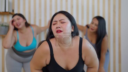 Photo for Group of plus size woman friends feeling tired during doing aerobics exercises together. Chubby woman friends feeling exhausted after training workout. Healthy lifestyle concept - Royalty Free Image