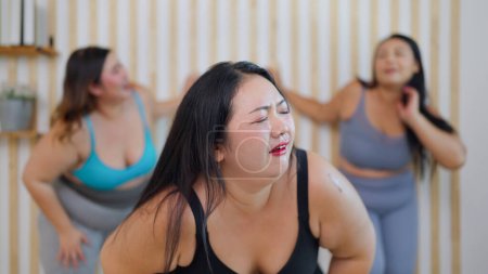 Photo for Group of plus size woman friends feeling tired during doing aerobics exercises together. Chubby woman friends feeling exhausted after training workout. Healthy lifestyle concept - Royalty Free Image