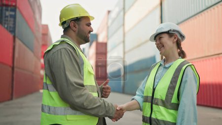 Foto de Dos ingenieros industriales hombre y mujer se dan la mano para celebrar el éxito trabajan juntos en el patio de contenedores de carga. Negocios de astilleros logísticos. Concepto de trabajo en equipo - Imagen libre de derechos