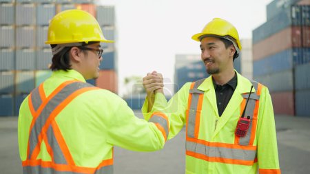 Photo for Two asian engineer or foreman shaking hand after working checking at container cargo harbor to loading containers. Two workers shaking hands for success working at container cargo harbor. Teamwork - Royalty Free Image