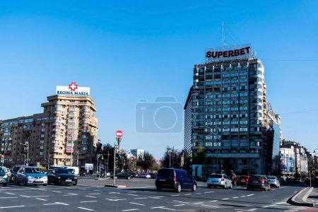 Photo for BUCHAREST, ROMANIA - MARCH 19, 2023: Victory square with Regina Maria and Superbet logos on the residential buildings. - Royalty Free Image