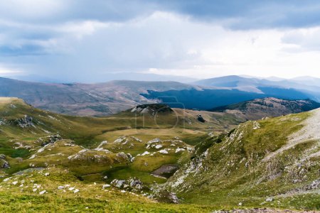 Téléchargez les photos : Paysage avec montagnes, collines verdoyantes et ciel nuageux, Transalpina road, Roumanie. - en image libre de droit