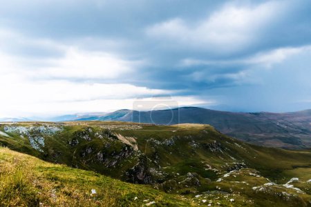 Foto de Paisaje con montañas, colinas verdes y cielo nublado, carretera Transalpina, Rumania. - Imagen libre de derechos