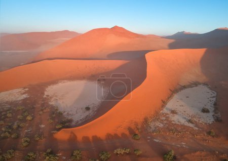 Téléchargez les photos : Formes et ombres de vastes dunes de sable orange, éclairées par le soleil levant. Vue Aérienne du Paysage Désertique du Parc National de Namib-Naukluft, Namibie. - en image libre de droit