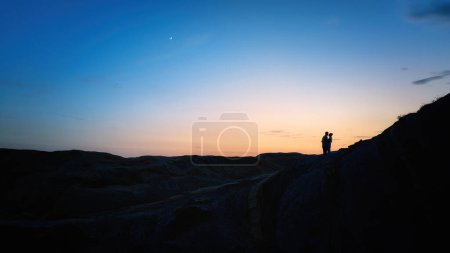 Photo for Couple silhouettes standing in meadow at sunset time - Royalty Free Image