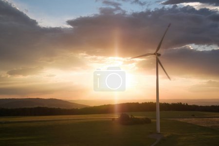 Photo for Silhouette of two wind  power plants in full load against sunset with clouds. Aerial view, drone inspection of wind turbine. - Royalty Free Image