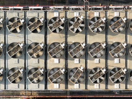 Foto de Vista aérea de las unidades de refrigeración de una central térmica. Montaje de potentes ventiladores giratorios enfriando el exceso de energía térmica en funcionamiento. Detalle del equipamiento de la central térmica. - Imagen libre de derechos