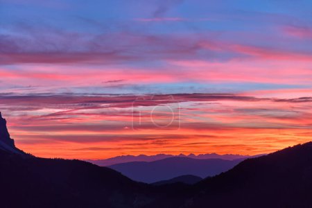 Téléchargez les photos : Coucher de soleil rouge sur Passo delle Erbe avec fond de sommets de Dolomite. Ciel coloré avec des nuances de rouge, orange et bleu, vue aérienne de haute altitude. - en image libre de droit