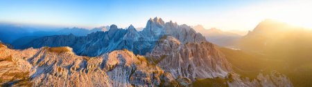 Téléchargez les photos : Panoramique, vue aérienne de Tre Cime di Lavaredo des sommets illuminés du massif de la Cime Eotvos, avec les trois millièmes Punta Sorapis et Antelao en arrière-plan, Dolomites, Italie. - en image libre de droit