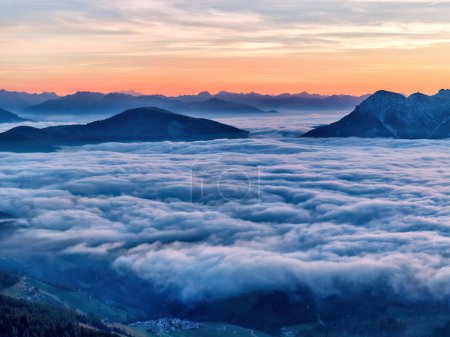 Foto de El amanecer sobre el Passo delle Erbe pasa sobre el telón de fondo de los picos de Dolomita, la cubierta de nubes inversa en el valle, los rayos del sol. Vista del dron. - Imagen libre de derechos