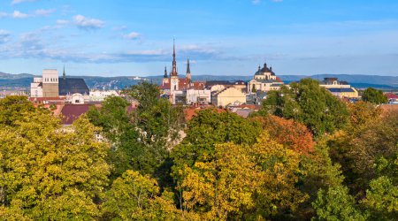 Téléchargez les photos : Vue panoramique à travers les arbres de couleur automne sur les tours et les temples du centre d'Olomouc, le centre historique de Moravie, République tchèque, site de l'UNESCO. Automne, journée ensoleillée, vue aérienne. - en image libre de droit