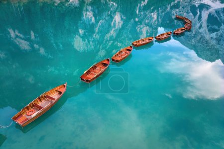Foto de Una vista artística y perpendicular de una forma de eje hecha de barcos de madera en la superficie de agua azul-verde del Lago di Braies en los Dolomitas. Ideal para proyectos de póster. - Imagen libre de derechos