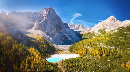 Téléchargez les photos : Automne coloré dans les Dolomites. Vue aérienne panoramique de l'eau azur du lac glaciaire Lago di Sorapiss entouré par le massif montagneux sous le pic Punta Sorapiss. Jour ensoleillé, ciel bleu. - en image libre de droit