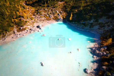 Téléchargez les photos : Automne coloré dans les Dolomites. Vue aérienne du lac glaciaire Lago di Sorapiss, contraste d'eau azur et de mélèzes orange, journée ensoleillée, randonneurs en trek. - en image libre de droit