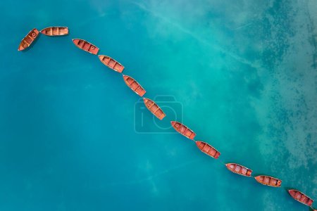 Photo for An artistic, perpendicular view of an axis shape made of wooden boats on the blue-green water surface of Lago di Braies in the Dolomites. Ideal for poster projects. - Royalty Free Image