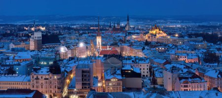Foto de Panorámica, vista de invierno de torres iluminadas e iglesias de la ciudad Olomouc en hora azul, sitio de la UNESCO, ciudad antigua y lugar turístico en Moravia Central, República Checa. - Imagen libre de derechos