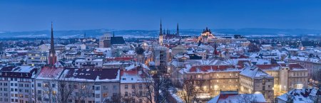 Téléchargez les photos : Panoramique, très détaillée, vue d'hiver en soirée des tours illuminées et des églises de la ville Olomouc à l'heure bleue, couverte de neige, site UNESCO, ancienne ville et lieu touristique en Moravie centrale, République tchèque. - en image libre de droit