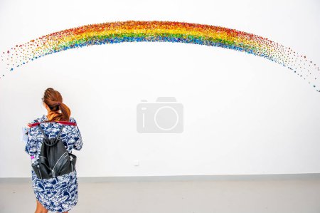Foto de Venice Italy August 22nd 2017: Tourist while observing a rainbow painted on the wall - Imagen libre de derechos