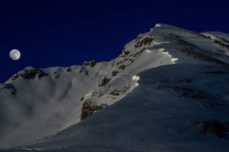 Snowy mountain at night with moon
