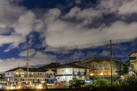 Téléchargez les photos : Lumières des immeubles résidentiels sous le nuage la nuit. Photo de haute qualité - en image libre de droit