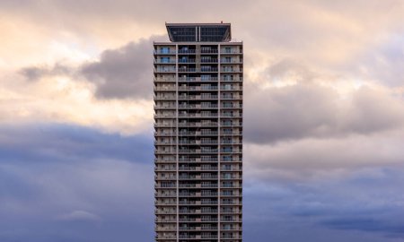 Dramáticas nubes detrás de la torre de apartamentos al atardecer. Foto de alta calidad