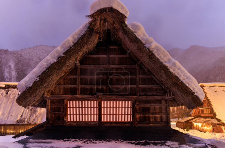 Foto de Snow covered thatched roof on traditional Japanese farmhouse at dawn. High quality photo - Imagen libre de derechos