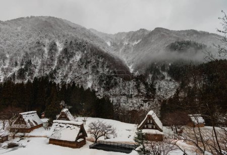 Foto de Traditional Japanese village and misty snow covered mountains in winter. High quality photo - Imagen libre de derechos
