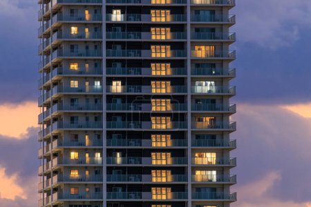 Foto de Lights from luxury apartment tower against beautiful sunset sky. High quality photo - Imagen libre de derechos