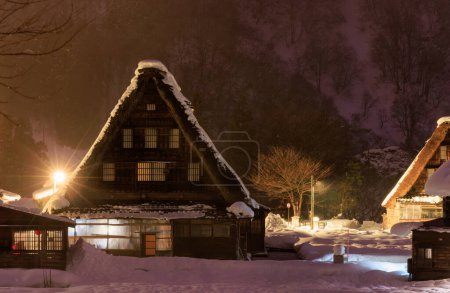 Foto de Traditional A-frame house in Gokayama amid snow and mist at night. High quality photo - Imagen libre de derechos
