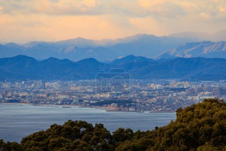 Photo for Beautiful Sunset Color in Sky Over Mountains and Sprawling City on Coast. High quality photo - Royalty Free Image