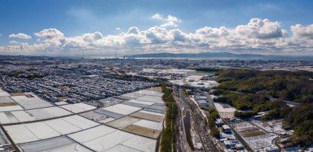 Photo for Aerial panorama of fresh snow on rice fields at edge of Akashi City on sunny winter day. High quality photo - Royalty Free Image