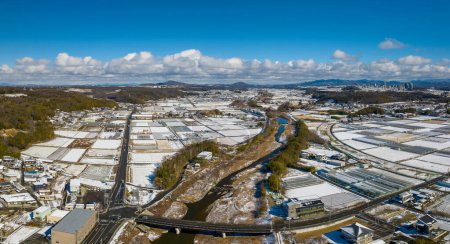 Photo for Aerial view of snow covered rice fields in Japanese countryside on sunny winter day. High quality photo - Royalty Free Image