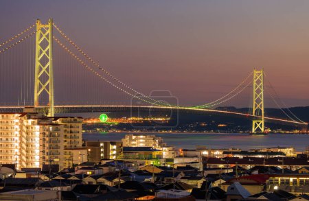 Photo for Akashi Suspension Bridge Lit with Rainbow Colors over City at Night. High quality photo - Royalty Free Image
