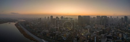 Téléchargez les photos : Panoramic aerial view of Yodo River and downtown Osaka before sunrise on misty morning. High quality photo - en image libre de droit