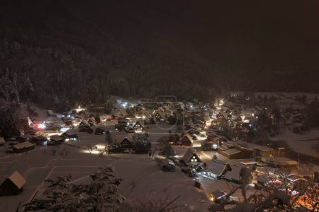 Foto de Las luces del tradicional pueblo de montaña atraviesan la nieve y la niebla por la noche. Foto de alta calidad - Imagen libre de derechos
