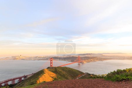 Photo for Red suspension bridge with city of San Francisco in distance at golden hour. High quality photo - Royalty Free Image