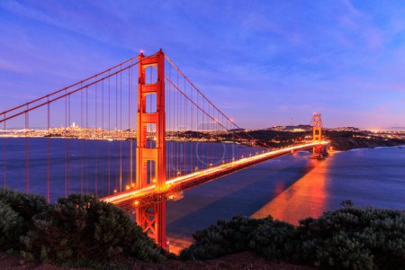 Photo for Car lights blur over Golden Gate Bridge with San Francisco lit at night. High quality photo - Royalty Free Image