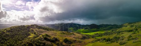Foto de Vista panorámica del sol brillante y las nubes de tormenta oscura sobre el paisaje verde de California. Foto de alta calidad - Imagen libre de derechos