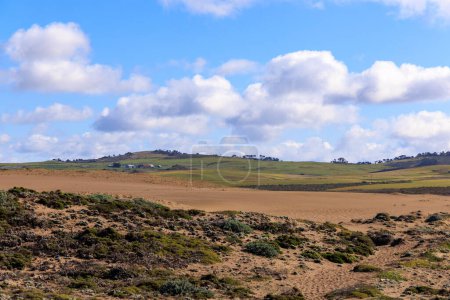 Téléchargez les photos : Ranch éloigné sur les collines verdoyantes près des dunes de sable par une journée ensoleillée à Point Reyes., Californie Photo de haute qualité - en image libre de droit