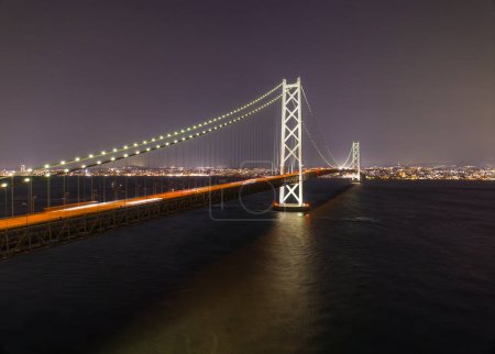 Photo for Car lights blur over Akashi Bridge with distant city at night. High quality photo - Royalty Free Image