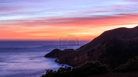 Pentes montagneuses dans l'océan Pacifique sur une côte accidentée avec un beau coucher de soleil. Photo de haute qualité