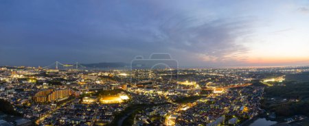 Photo for Panoramic aerial view of lights in small city and suspension bridge at sunset. High quality photo - Royalty Free Image