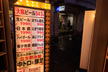Foto de Osaka, Japón - 29 de abril de 2023: Signo iluminado en japonés con los precios de la comida de bar en el restaurante por estación. Foto de alta calidad - Imagen libre de derechos