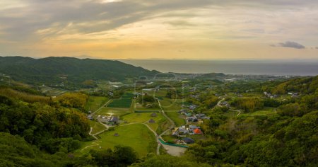 Photo for Panoramic aerial view of green fields and thatched huts in coastal landscape. High quality photo - Royalty Free Image