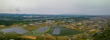 Panoramic aerial view of solar panels floating on reservoirs by farms. High quality photo